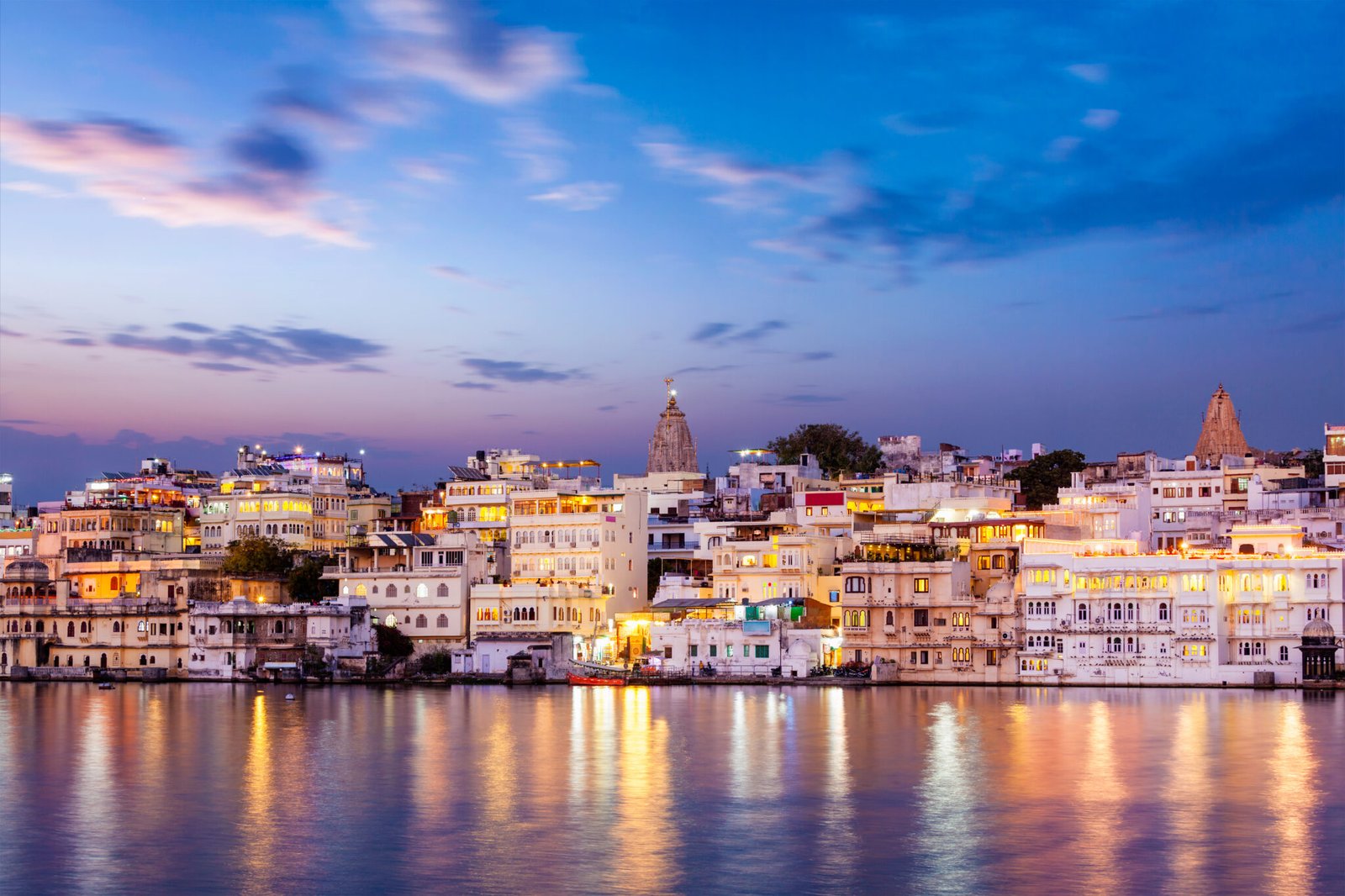 Evening view of illuminated houses on lake Pichola in twilight, Udaipur, Rajasthan, India